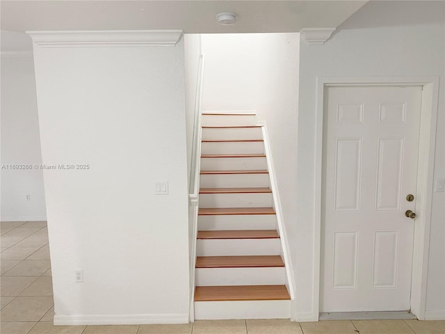 stairs with tile patterned flooring and crown molding