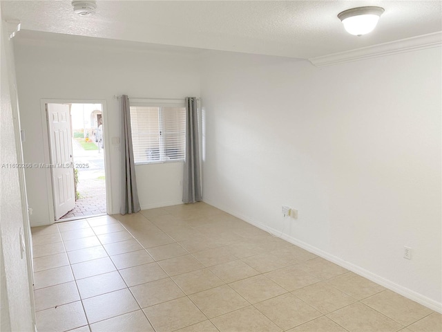 unfurnished room featuring a textured ceiling, light tile patterned flooring, and crown molding