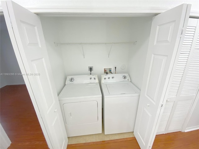 laundry area featuring hardwood / wood-style flooring and washing machine and dryer