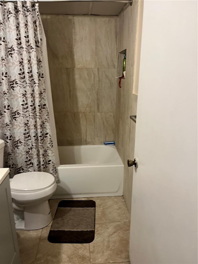 full bathroom with tile patterned flooring, shower / bath combo with shower curtain, vanity, and toilet