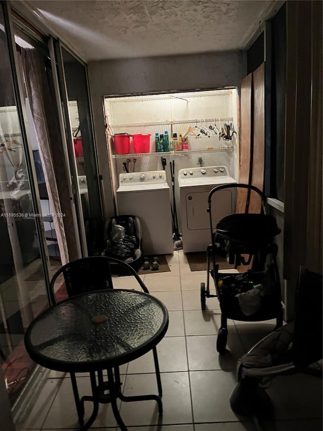 interior space featuring light tile patterned floors, washing machine and dryer, and a textured ceiling