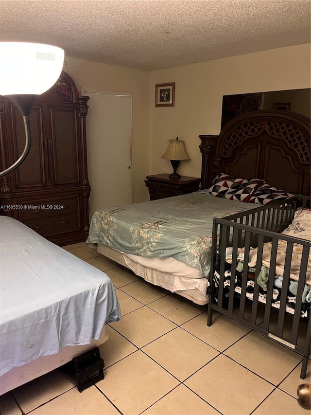 tiled bedroom featuring a textured ceiling