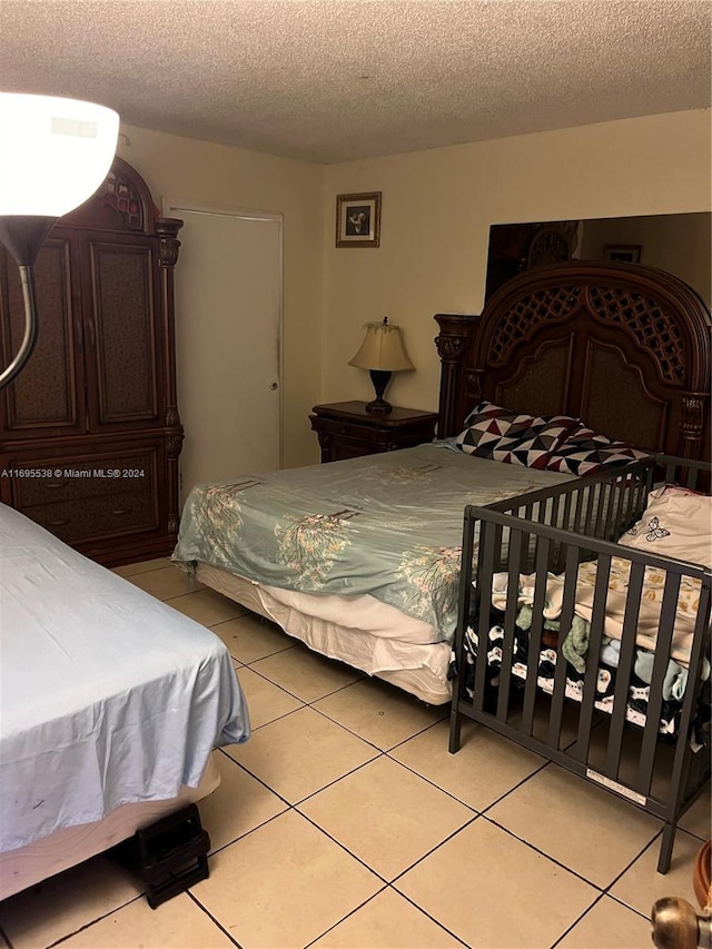 tiled bedroom with a textured ceiling