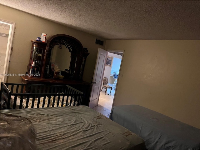 tiled bedroom featuring a textured ceiling