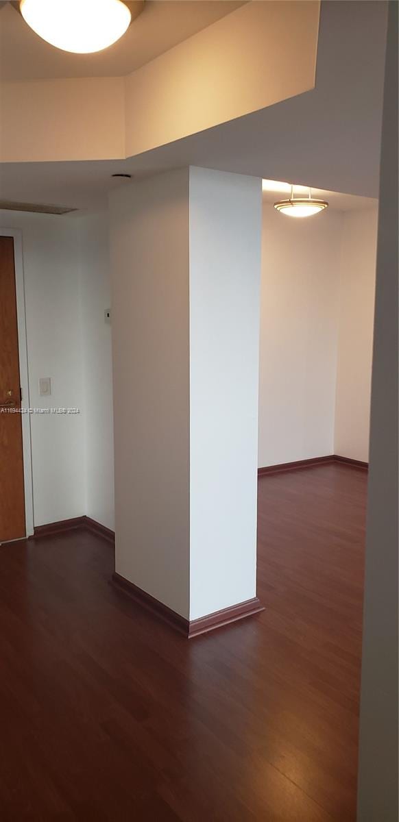 unfurnished room featuring dark wood-type flooring