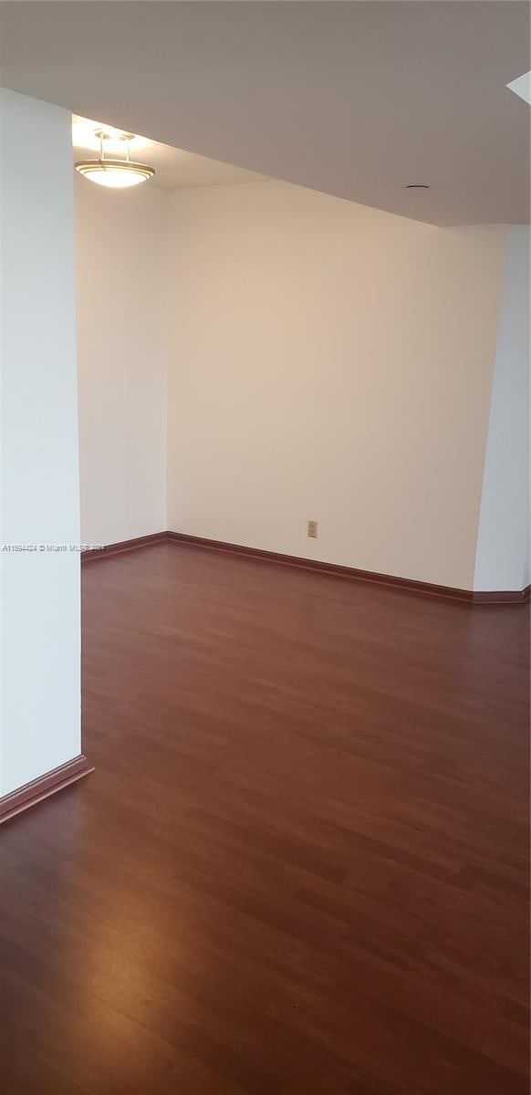 unfurnished room with dark hardwood / wood-style floors