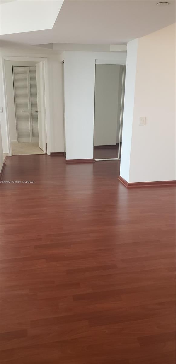 empty room with dark hardwood / wood-style flooring