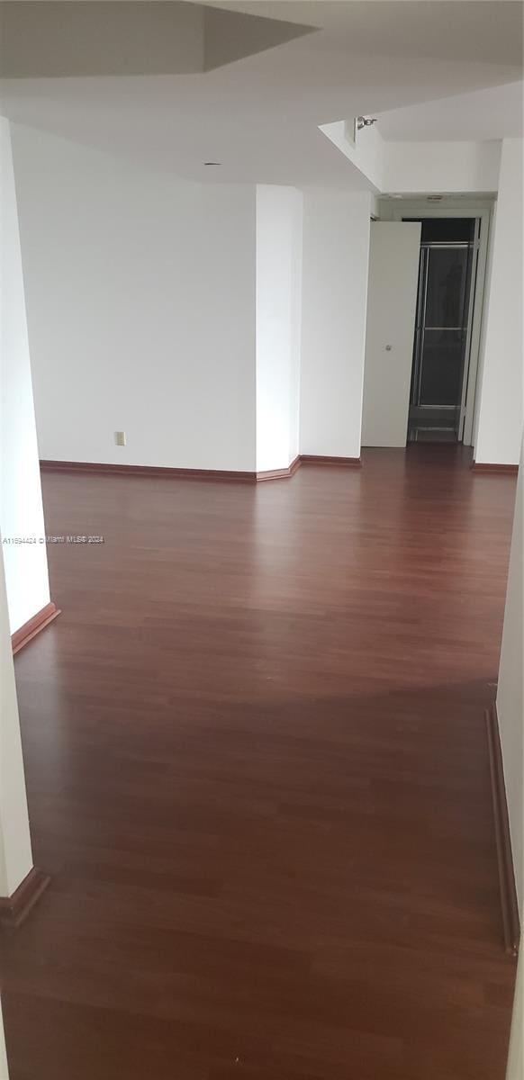 unfurnished room with dark wood-type flooring