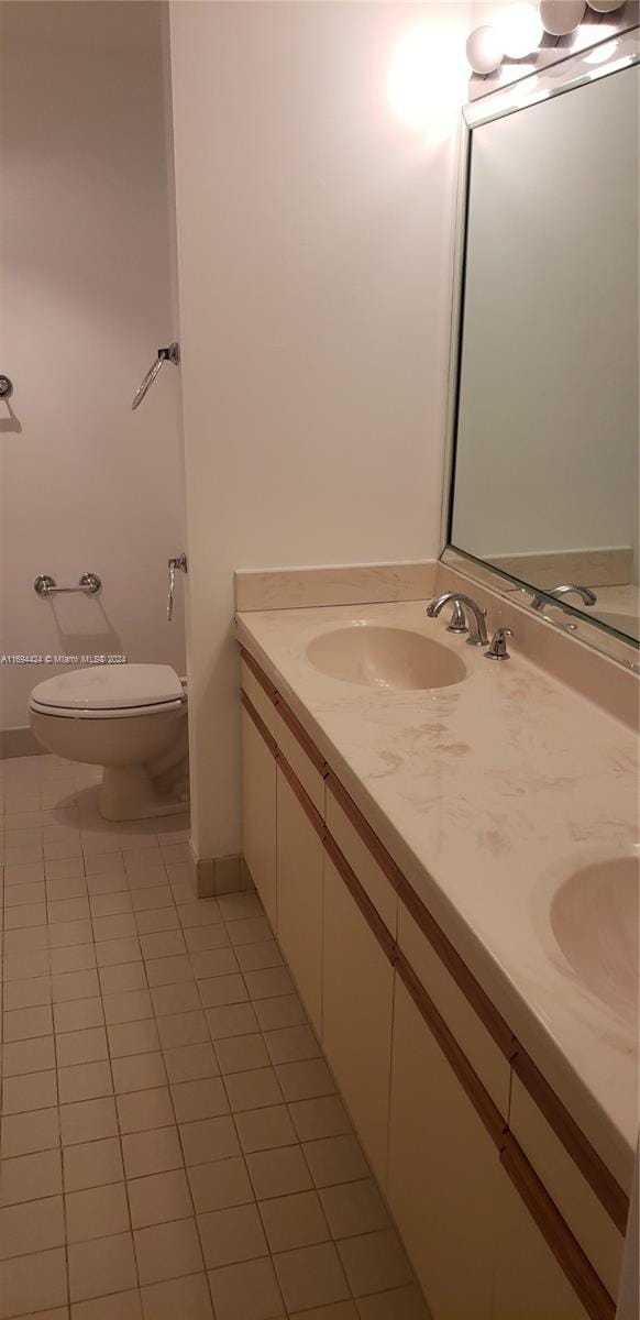 bathroom with tile patterned flooring, vanity, and toilet