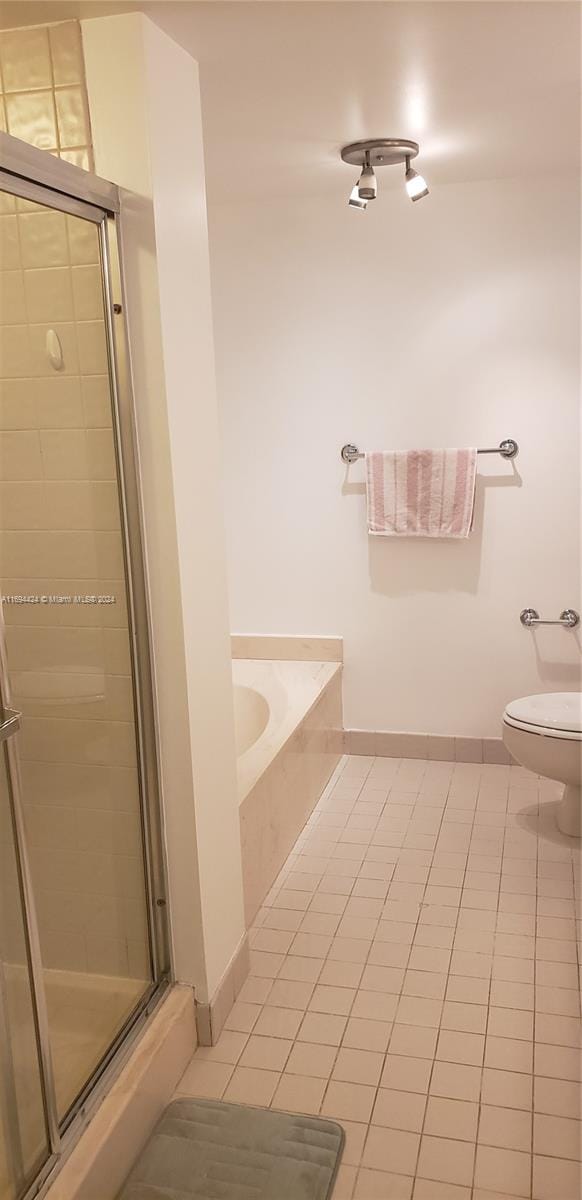 bathroom with tile patterned floors, toilet, and independent shower and bath