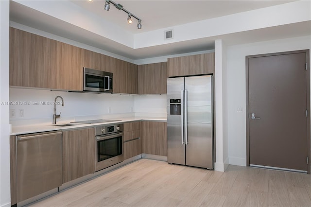 kitchen featuring appliances with stainless steel finishes, light wood-type flooring, and sink