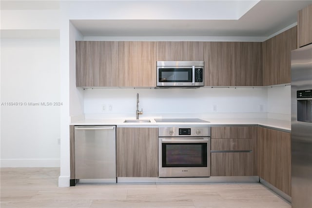 kitchen featuring sink, stainless steel appliances, and light hardwood / wood-style flooring