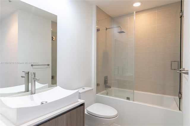 full bathroom with vanity, toilet, and bath / shower combo with glass door