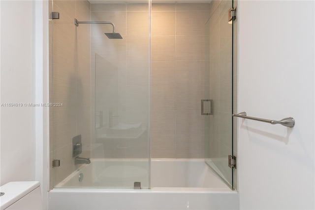 bathroom featuring toilet and enclosed tub / shower combo