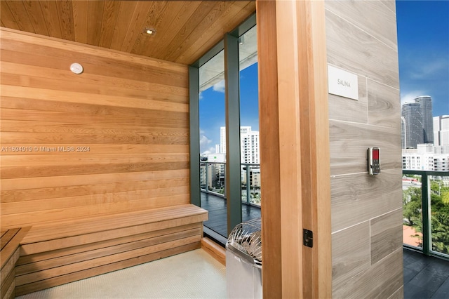 view of sauna featuring hardwood / wood-style flooring, wood ceiling, and wooden walls