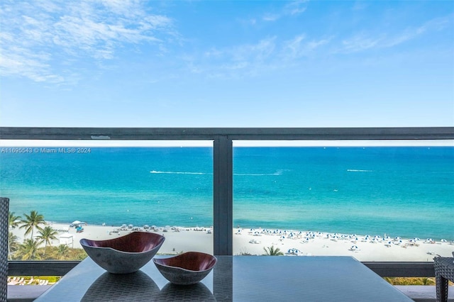 balcony with a water view and a view of the beach