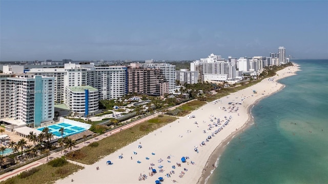 birds eye view of property with a water view and a beach view