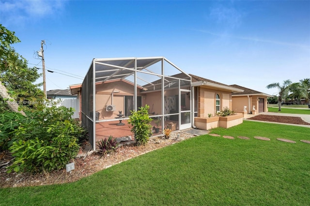 rear view of property with a lanai and a yard