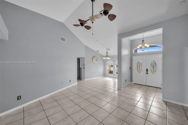 foyer entrance featuring french doors, ceiling fan with notable chandelier, high vaulted ceiling, and light tile patterned flooring