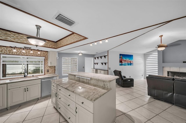 kitchen with white cabinets, sink, a center island, and stainless steel dishwasher