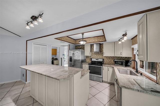 kitchen with light stone countertops, wall chimney exhaust hood, stainless steel appliances, sink, and a kitchen island