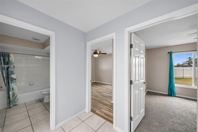 bathroom with tile patterned floors, shower / bath combination with curtain, ceiling fan, and toilet