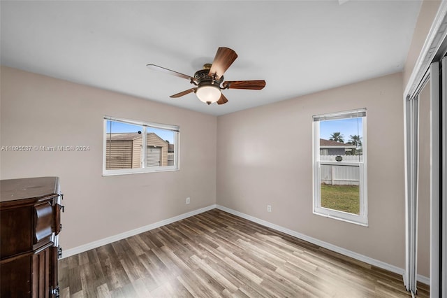 unfurnished bedroom with multiple windows, ceiling fan, and light hardwood / wood-style floors