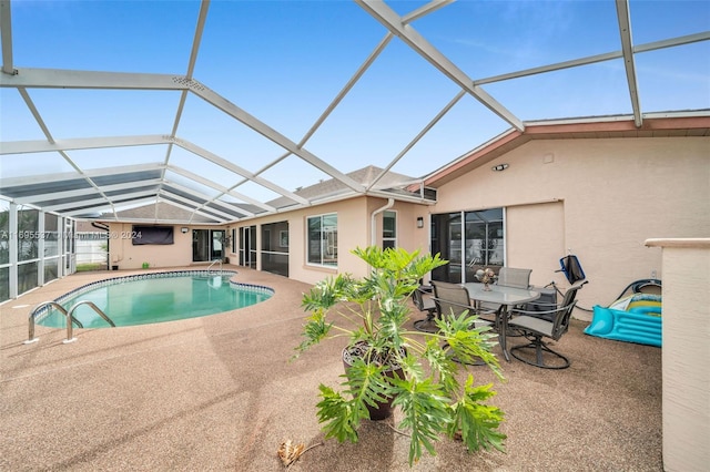 view of pool with glass enclosure and a patio