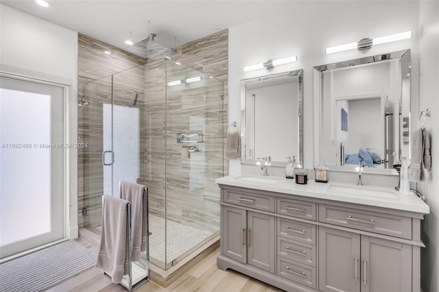 bathroom with hardwood / wood-style floors, vanity, and a shower with shower door