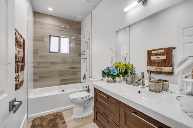 full bathroom featuring vanity, wood-type flooring, tiled shower / bath combo, and toilet