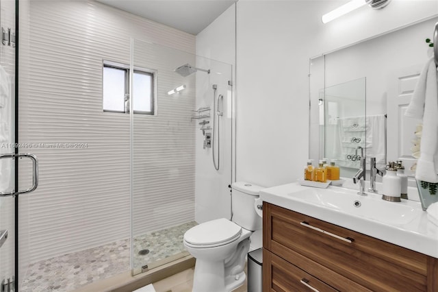 bathroom with an enclosed shower, vanity, and toilet