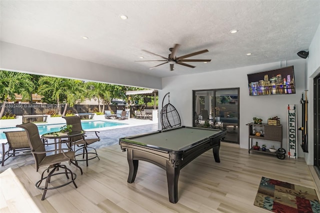 recreation room featuring a textured ceiling, light hardwood / wood-style flooring, and billiards