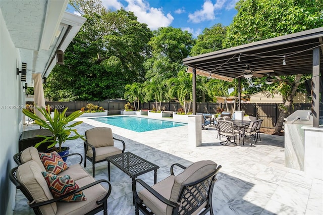 view of pool with ceiling fan, a patio area, and an outdoor hangout area