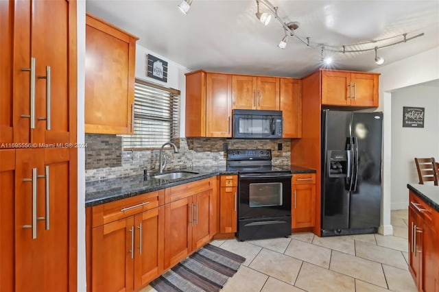 kitchen featuring decorative backsplash, dark stone counters, sink, black appliances, and light tile patterned floors