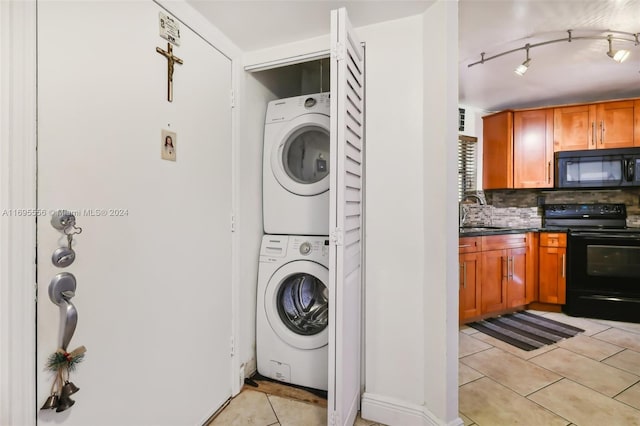 laundry area featuring light tile patterned flooring, sink, and stacked washer and dryer