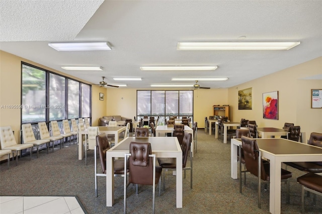 tiled dining room with plenty of natural light, ceiling fan, and a textured ceiling