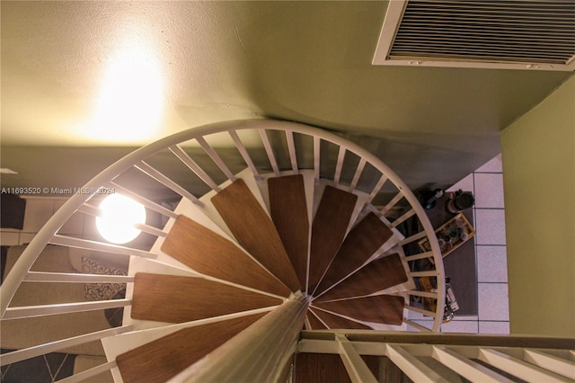 stairway featuring a textured ceiling