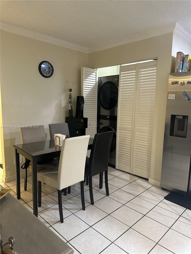 dining room with stacked washer / dryer, light tile patterned flooring, and ornamental molding