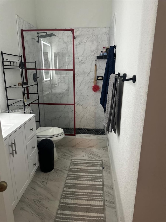 bathroom featuring tiled shower, vanity, and toilet