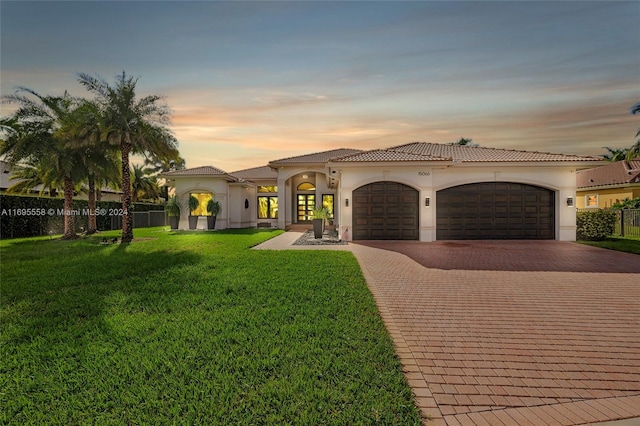 mediterranean / spanish house featuring a yard and a garage