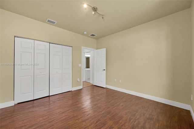 unfurnished bedroom featuring dark hardwood / wood-style flooring and a closet