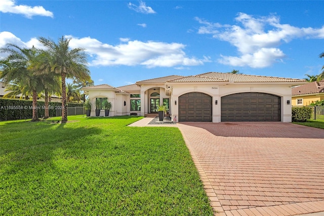 mediterranean / spanish house with a front yard and a garage