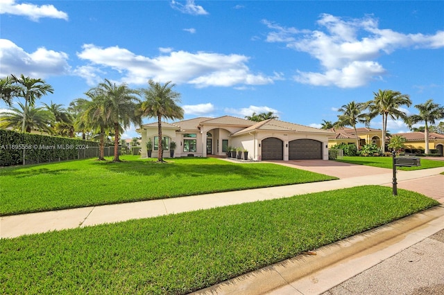 mediterranean / spanish home with a garage and a front lawn