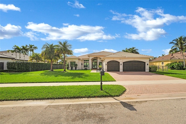 mediterranean / spanish house featuring a garage and a front lawn