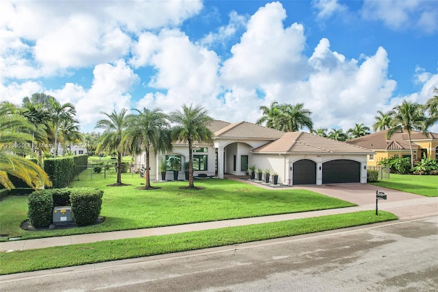 mediterranean / spanish-style home featuring a front yard and a garage