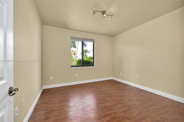 spare room featuring dark wood-type flooring