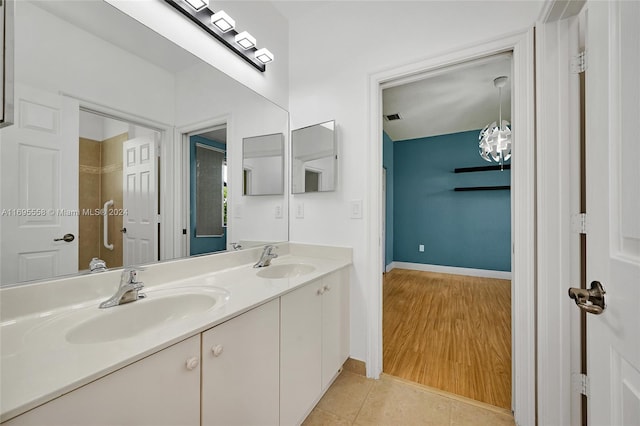 bathroom with tile patterned flooring, vanity, and a chandelier