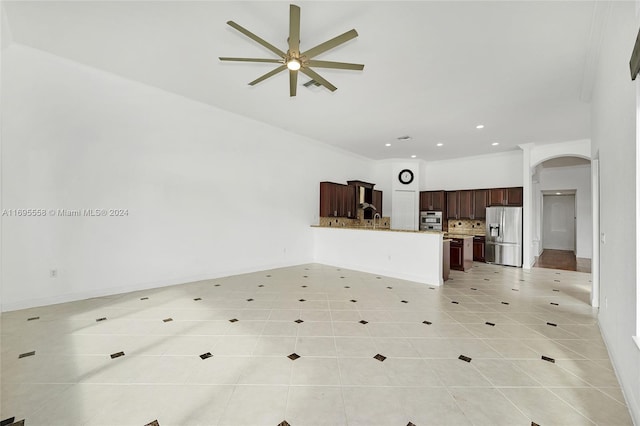 unfurnished living room with ceiling fan, light tile patterned floors, and ornamental molding