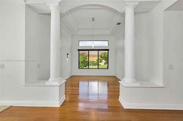 interior space with hardwood / wood-style floors, a raised ceiling, and ornamental molding