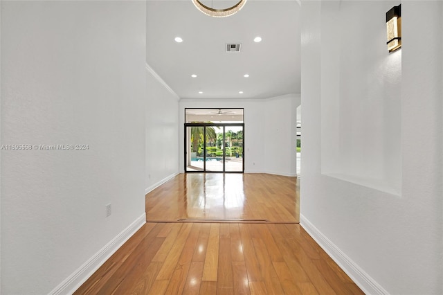 hallway featuring wood-type flooring and crown molding